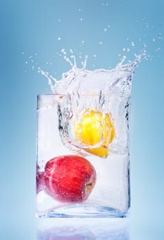 Apple and orange thrown in aquarium with water