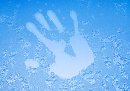 Print of  hand of  hand on cold glass covered with hoarfrost