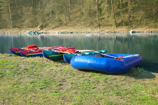 Catamarans and inflatable boat on the bank of the beautiful river