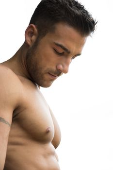 Handsome shirtless muscular man portrait looking down at his chest, side view, isolated on white