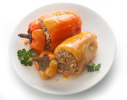 Two stuffed peppers with fresh parsley on the white plate