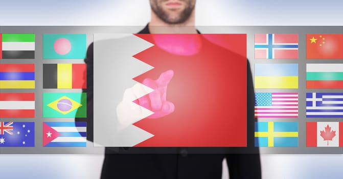 Hand pushing on a touch screen interface, choosing language or country, Bahrain