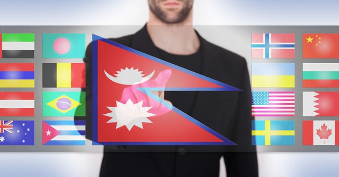 Hand pushing on a touch screen interface, choosing language or country, Nepal