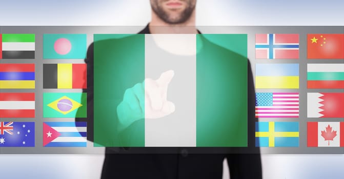 Hand pushing on a touch screen interface, choosing language or country, Nigeria