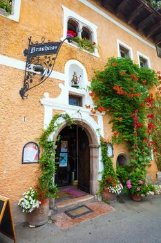 Hallstatt, Austria - August 7, 2013: Typical guest house covered with flower plants in Hallstatt village, Austria