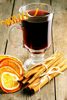 Glass of red mulled wine on wooden table