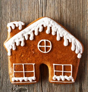 Christmas homemade gingerbread house cookie on wooden table