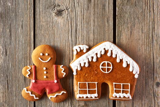 Christmas homemade gingerbread man and house on wooden table