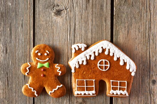 Christmas homemade gingerbread man and house on wooden table