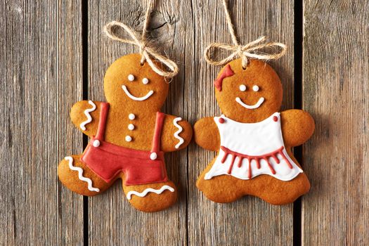 Christmas homemade gingerbread couple cookies over wooden background