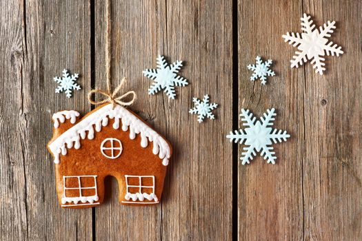 Christmas homemade gingerbread house cookie over wooden background