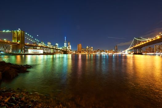 Manhattan skyline view at night from Brooklyn between Brooklyn Bridge and Manhattan Bridge in New York City