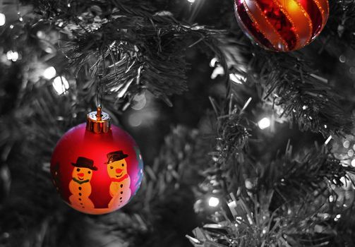 Two Christmas baubles, in color, against a black and white background
