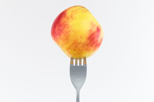Apple on a fork, visible drops of juice