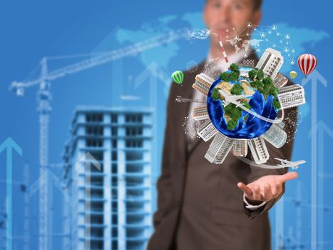 Businessman holding earth. Buildings as backdrop. Element of this image furnished by NASA