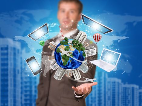 Businessman holding earth with electronics. Buildings as backdrop. Element of this image furnished by NASA