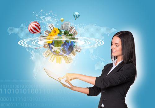 Beautiful businesswomen in suit using digital tablet. Earth with buildings, air balloons, flowers and airplane. Element of this image furnished by NASA
