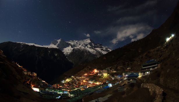 Night sky and stars passing by behind mountain Kongde Ri, Namche Bazaar village. Nepal
