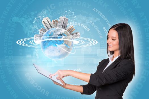 Beautiful businesswomen in suit using digital tabletEarth with buildings and business words. Element of this image furnished by NASA