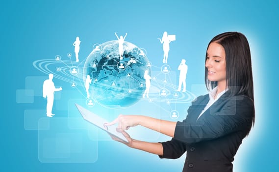 Beautiful businesswomen in suit using digital tablet. Earth with silhouettes of business people. Element of this image furnished by NASA