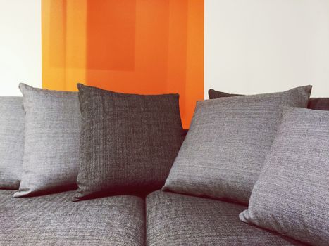 Close-up of modern gray fabric sofa with cushions.