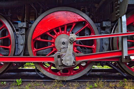 red wheels of an old steam locomotive standing on rail