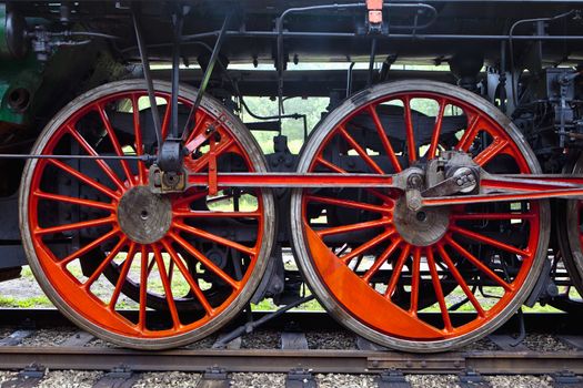 red wheels of an old steam locomotive standing on rail