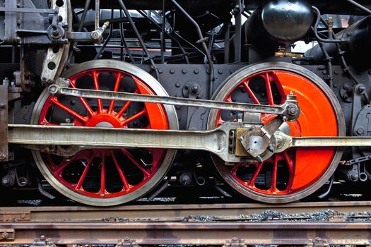 red wheels of an old steam locomotive standing on rail