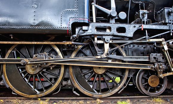 wheels of an old steam locomotive standing on rail