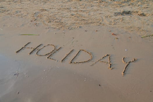 Photo shows a detail of the sign in the beach sand.