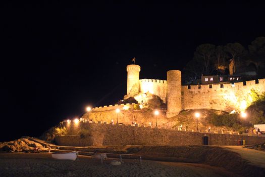 Photo shows Spanish coast castle and its surroundings at night.