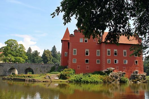 Photo shows red castle house and its surroundings.