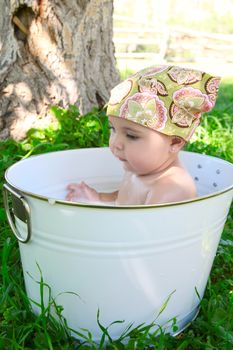 Beautiful baby girl having a bath outdoors 