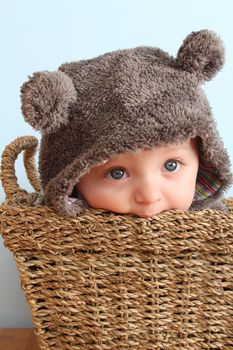 Four month old baby boy wearing a fully bear suit 