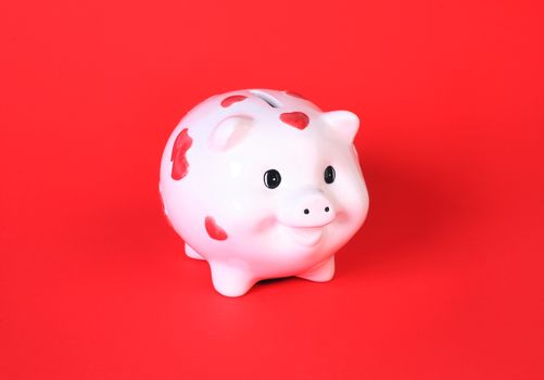 White pig-coin box on red background
