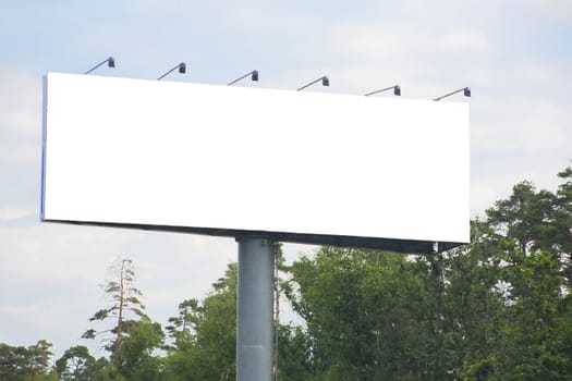 White rectangular billboard near road against the sky.