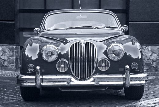 Facade of  beautiful old prestigious car against wall