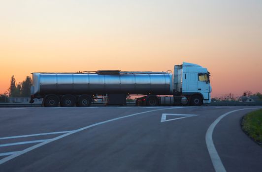 gas-tank truck with  chromeplated tank goes on road in morning