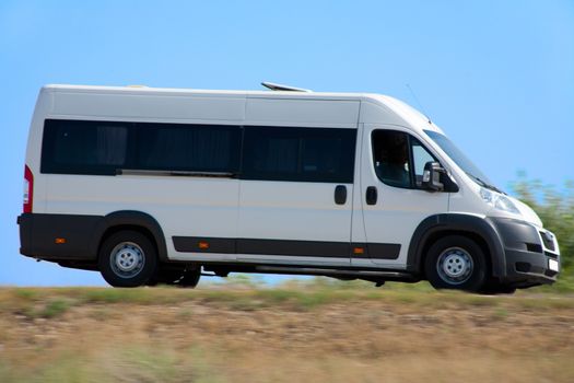 white minibus goes on country highway
