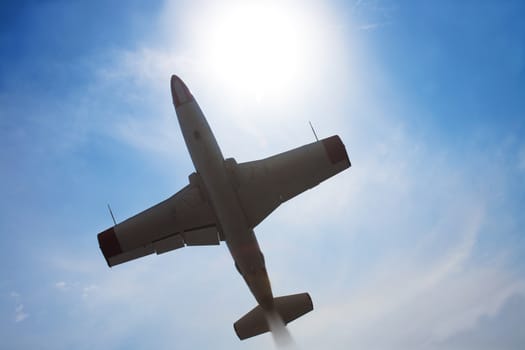 military plane in the sky against the sun