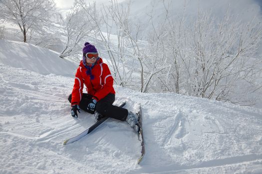 Female skier fallen in deep snow