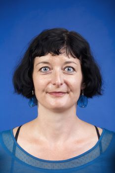 portrait of middle-aged woman with dark hair - isolated on blue