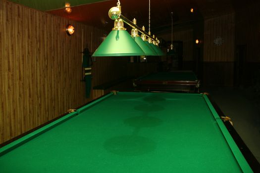 Billiard table with green cloth in playing room