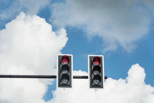 the traffic Light in a blue sky with only the red light on.