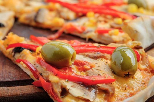 MAcro closeup of pizza with mozzarella, mushrooms, olives and red bell pepper