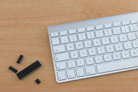 Metal keyboard with white keys and four computer parts on office desk