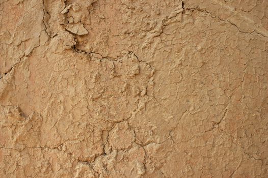 Background texture of mud wall plaster with cracks
