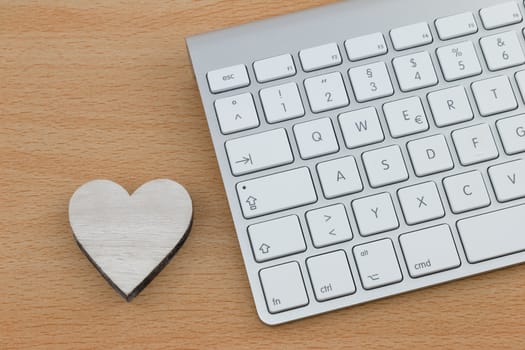 Sending love mails, wooden heart next to keyboard