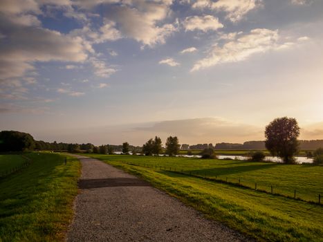 Path along the river Ijssel in Holland be sunset light