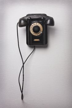Old black rotational phone on wall